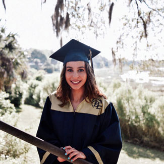 gabriella smiling in a graduation cap and gown