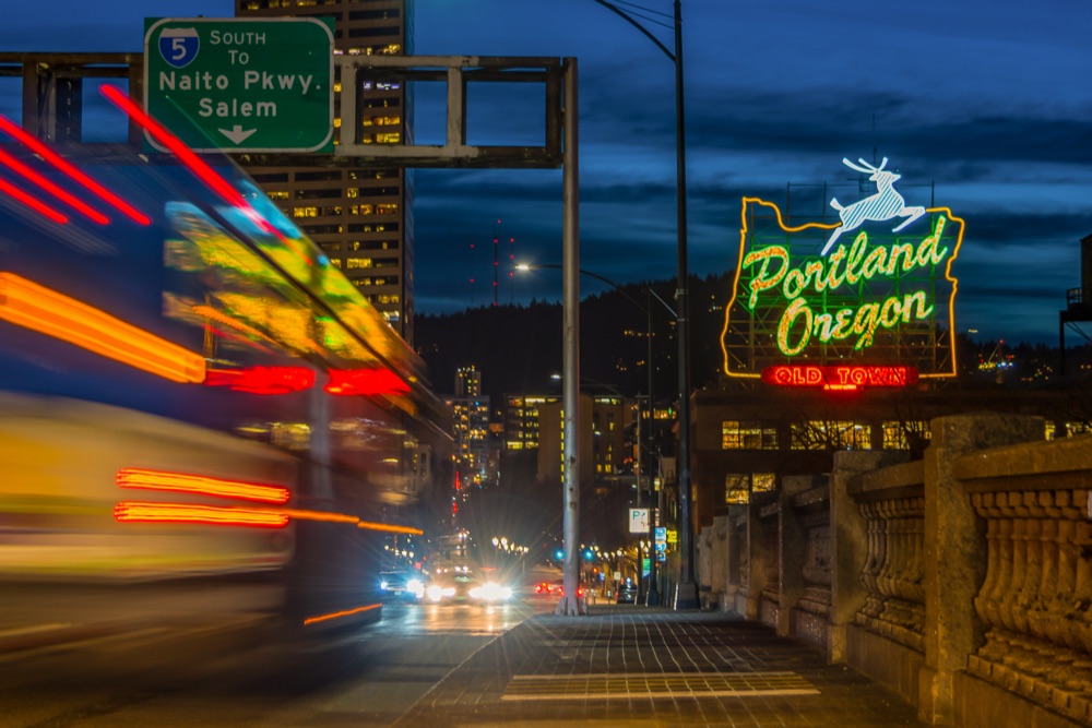 The Portland Oregon sign illuminated at dusk.
