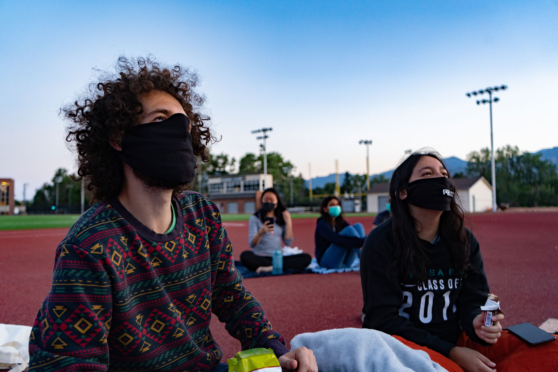 Students enjoy an outdoor socially distanced movie.